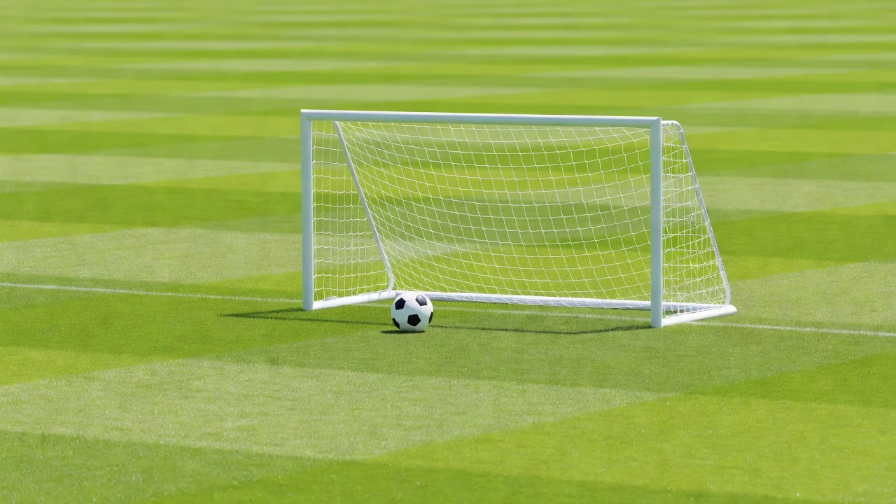 A ball rolled to the side of a goal during a distribution drill on bright grass